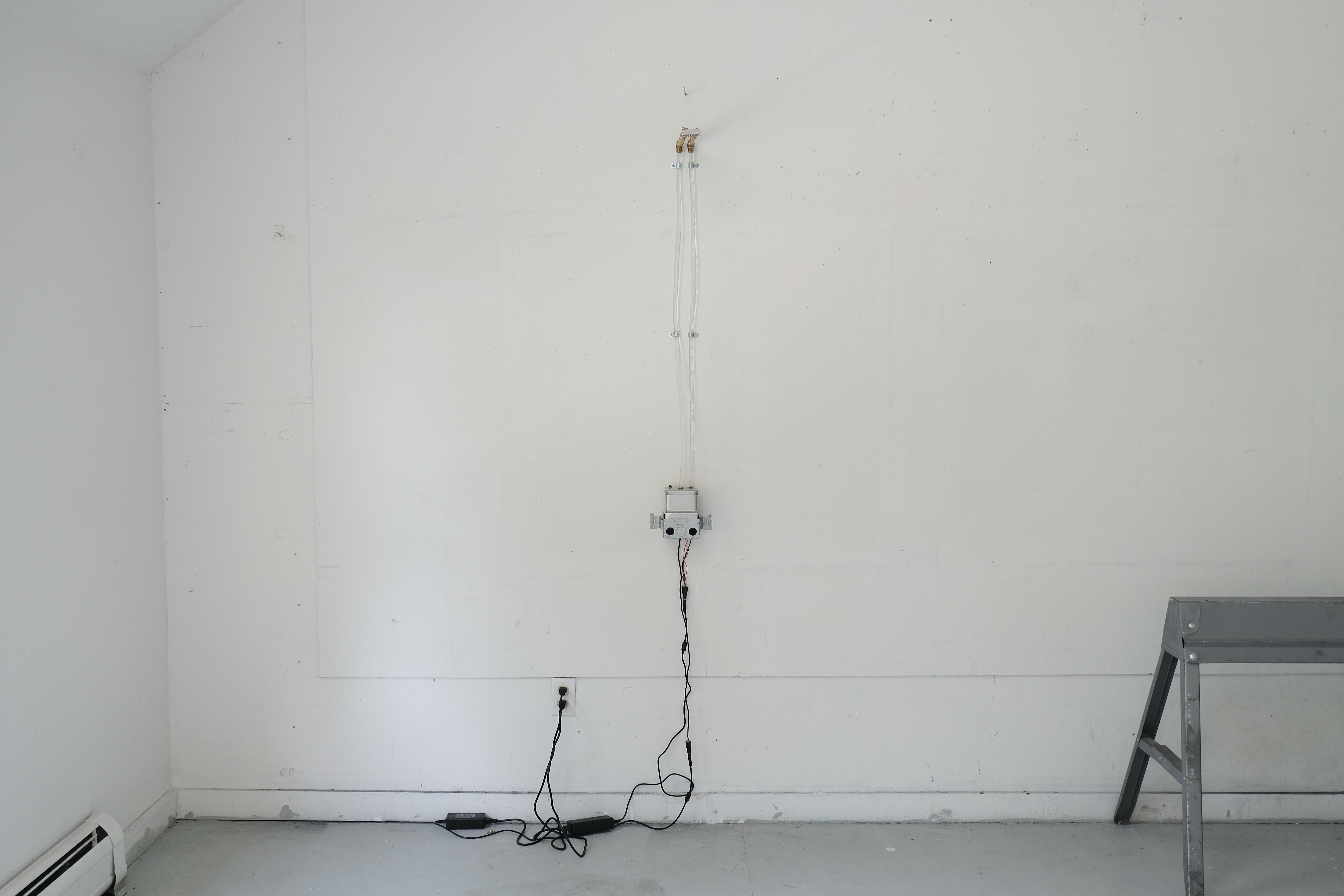 Installation shot of a condensation shower device made out of CPU cooling system.